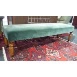 A Victorian window seat upholstered in turquoise plush on turned legs and brass castors,