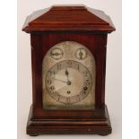 An early 20th Century mahogany cased bracket clock with arched silvered dial and two subsidiary