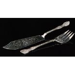 A Victorian hallmarked silver fish knife and fork with shell and scroll handle above pierced blade,
