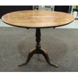 A 19th Century country oak snap top table of circular form,