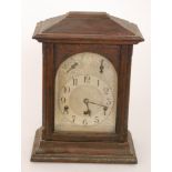 An early 20th Century oak cased mantle clock with eight day chiming movement and silvered dial