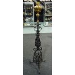 A Victorian adjustable wrought iron and brass standard lamp with leaf scroll base,