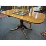 A 19th Century Regency style crossbanded mahogany rectangular dining table on turned pedestal and