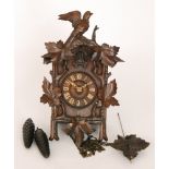 A late 19th Century Black Forest cuckoo clock in carved walnut traditional case mounted with a