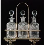 An early 20th Century tantalus with three Thomas Webb & Sons crystal glass decanters of barrel form