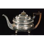A George III hallmarked silver boat shaped tea pot with part bright cut engraved decoration