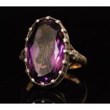 An oval mixed cut amethyst ring with diamond set shoulders, plain yellow metal band, weight 10g,