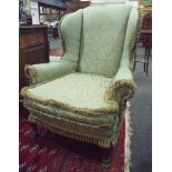 A pair of Edwardian Queen Anne style wing back easy arm chairs on carved hoof feet upholstered in