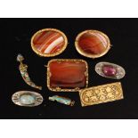 Three gilt metal mounted banded agate brooches, two pewter brooches each with central cabochon,