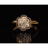 An Edwardian 18t diamond flower head ring designed with seven old European cut diamonds pave set