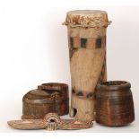 An African goat skin and painted drum together with three wooden food containers,