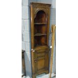 A 17th Century style carved oak floorstanding corner cupboard of narrow proportions,