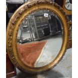 A 19th Century bevelled glass oval wall mirror in raised gilt leaf frame,