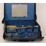 An early 20th Century blue leather travelling dressing case with fall front compartment opening to