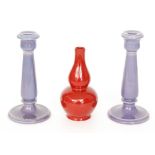 A pair of early 20th Century Ault Pottery candlesticks each glazed in purple with beaded detailing,