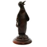 A small 20th Century novelty bronze figure of a penguin holding a handbag on turned mahogany base,
