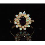 A 9ct hallmarked amethyst and opal cluster ring, central amethyst within a two row opal set border,