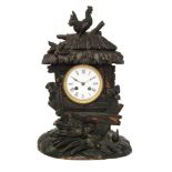 A late 19th Century Black Forest carved walnut mantle clock in the form of a thatched barn with