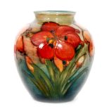 A small Moorcroft vase decorated in the flambe African Lily pattern with tubelined flowers and