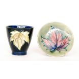 Two pieces of Moorcroft Pottery comprising a footed beaker vase and a small pin dish coaster each