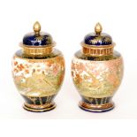 A pair of late 19th Century Japanese Satsuma vase and covers each decorated with pheasants amidst