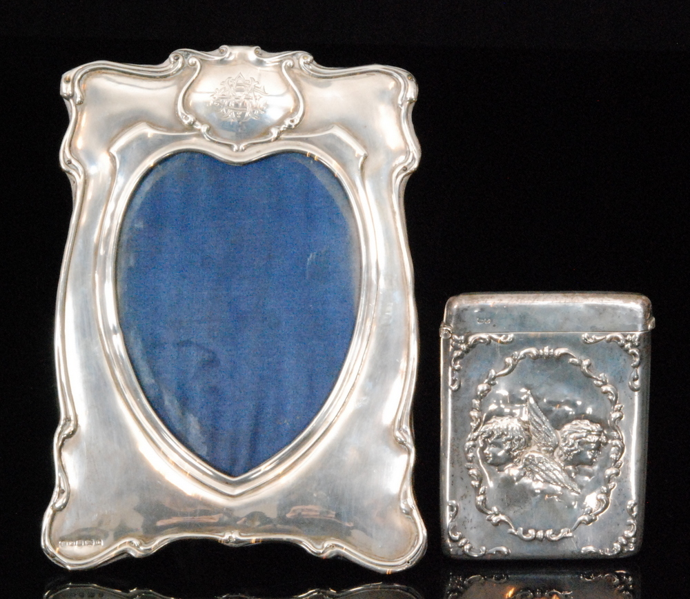 An Art Nouveau hallmarked silver rectangular card case embossed with cherubs heads within a