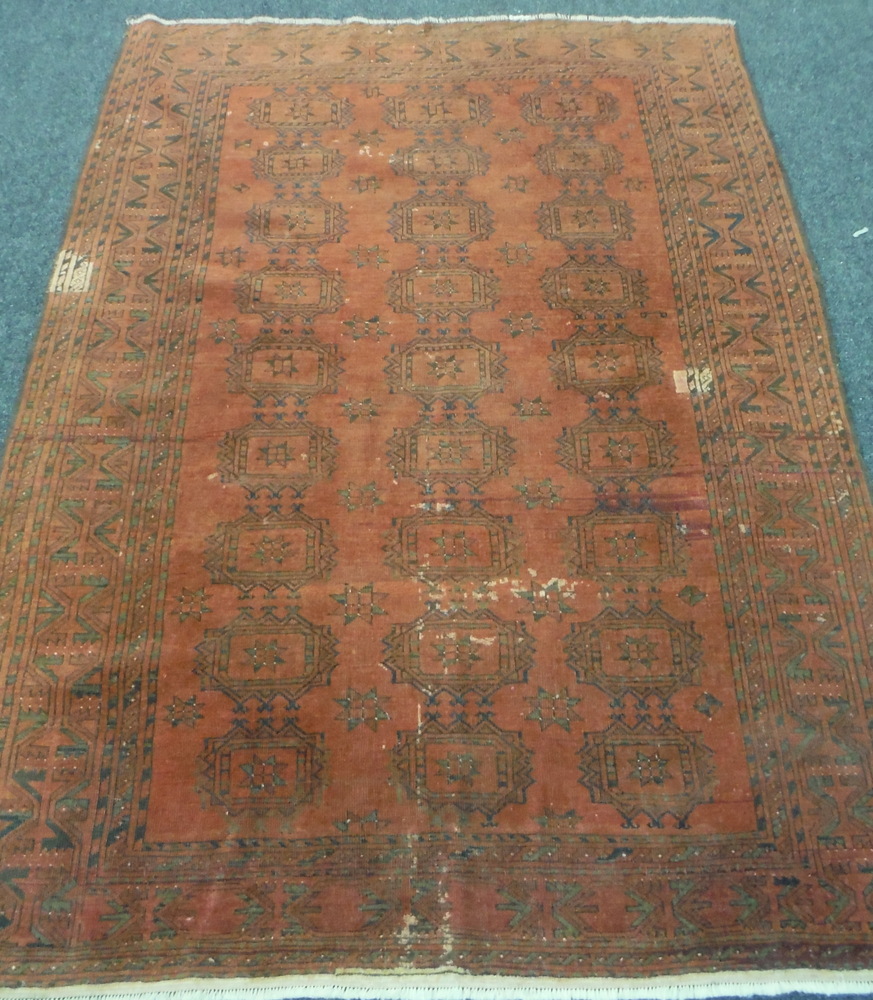 An early 20th Century Middle Eastern flat woven maroon rug, with repeat pattern, 227cm x 166cm, A/F.