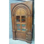 A 19th Century oak floorstanding corner cupboard the shaped shelves enclosed by a bar glazed door