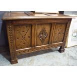 An 18th Century style carved oak coffer with lozenge panelled front on stiles,
