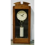 A 20th Century Gents pegging in wall mounted clocking in clock with circular dial in beech glazed