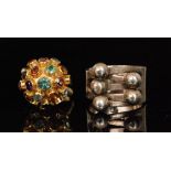 A modern 18ct multigem ring designed with a domed head set with coloured gems to a plain band and a