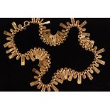 A 1970s 9ct fringe style necklace formed of textured and fluted alternating short and long gold