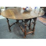 An 18th Century oak and walnut gateleg dining table on turned legs and stretchers with splayed hoof