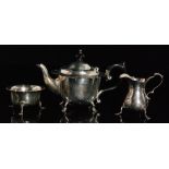 A George V hallmarked silver teapot of small proportions with scalloped rim and plain body above