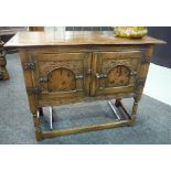 A 17th Century style oak cupboard enclosed by a pair of carved and flral marquetry inlaid doors on