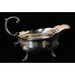 A George II hallmarked silver sauce boat with scalloped border and acanthus leaf capped flying