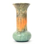 A Ruskin Pottery crystalline glaze vase of globe and shaft form decorated with a streaked and