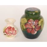 A Moorcroft Clematis pattern ginger jar and cover decorated with tubelined flowers against a green