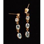 A pair of aquamarine pendant earrings designed with three collar set stones to push and post