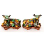 A pair of Chinese models of water buffalo decorated in brown, mustard and green patches,