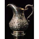 A Victorian hallmarked silver cream jug decorated with part embossed and engraved foliate details