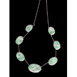 An 18ct white gold and Chinese jadeite necklace formed of seven graduated jadeite panels each with