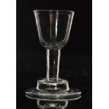An 18th Century drinking glass circa 1730, round funnel bowl above a short plain stem,