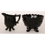 A late 19th Century Henry Greener black pressed glass sugar bowl the four swept feet below the wide