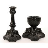 A late 19th Century black pressed glass candlestick attributed to Davidson the triform base formed