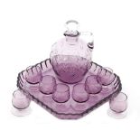 A 1930s Czechoslovakian crystal glass liqueur set comprising of a toddy jug in pale amethyst with a