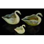 A pair of two late 19th Century Burtles & Tate swans a graduated yellow to opalescent, length 20cm,