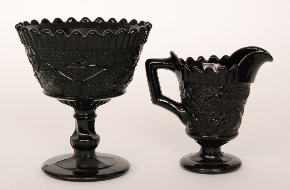 A late 19th Century Davidson black pressed glass pedestal sugar bowl relief moulded with trailing