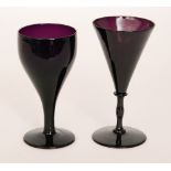 A late 19th Century deep amethyst wine glass with a conical bowl with basal bladed knop and slender