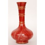 A late 19th Century Loetz Carneol glass vase of footed globe and shaft form with gilt bands on the